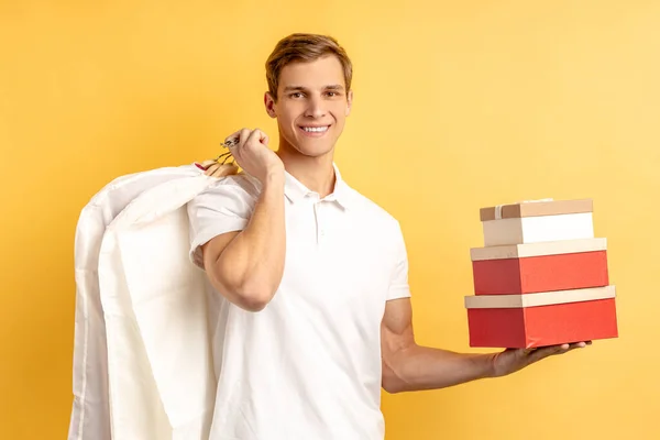 Agradable joven repartidor hombre con cajas y ropa —  Fotos de Stock