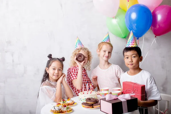 Забавная девушка смотрит торт, пока ее друзья позируют перед камерой — стоковое фото
