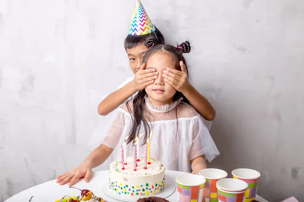 Menino bonito cobrindo os olhos das meninas com as mãos — Fotografia de Stock