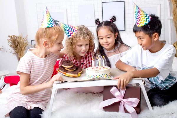 Jolis enfants réunis autour d'un gâteau savoureux — Photo