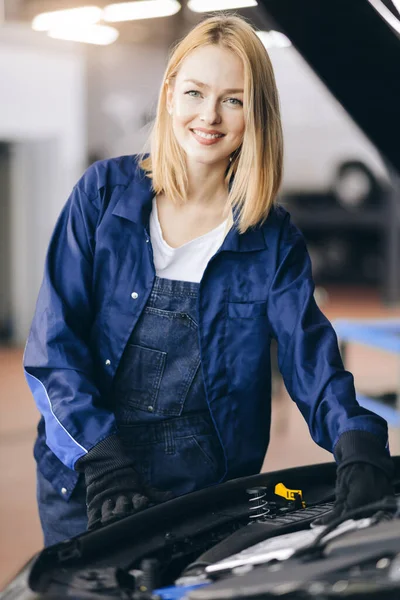 Positiver Charming Frau in spezieller Uniform und Handschuhen bei der Arbeit in der Garage — Stockfoto