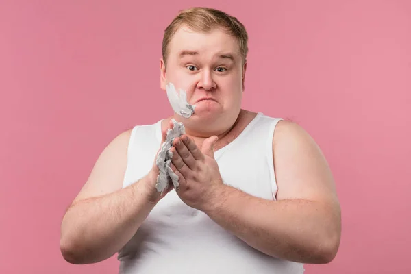 Scheerconcept. Geïrriteerde man gaat baard scheren, houdt scherp scheermes en borstel vast — Stockfoto