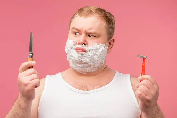 Conceito de barbear. Irritado homem vai barbear barba, segura navalha afiada e escova — Fotografia de Stock