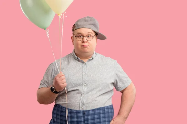 Adulto tubby uomo guarda e vestito come un bambino in posa con palloncini d'aria. — Foto Stock