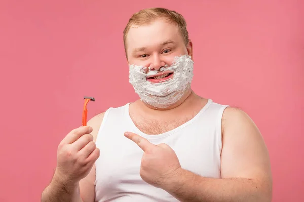 Feliz homem gordo com espuma de barbear em seu rosto e navalha isolada em rosa — Fotografia de Stock