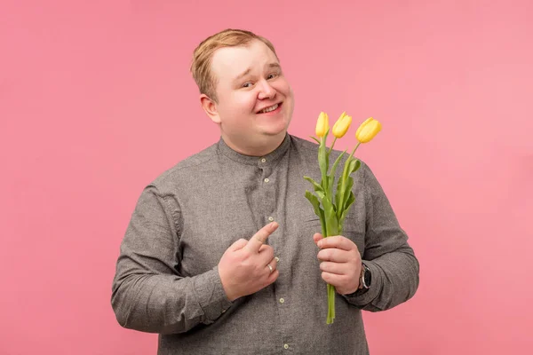 Emotivní manžel představuje kytici tulipánů, chce překvapit svou ženu — Stock fotografie