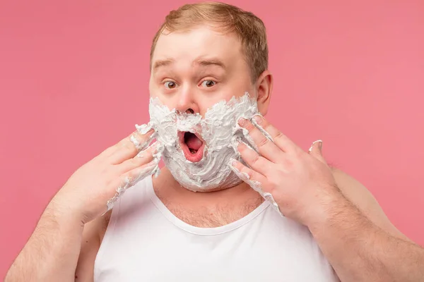 El hombre asombrado tiene espuma de afeitar en la cara, sentirse impresionado por el nuevo gel de afeitar — Foto de Stock