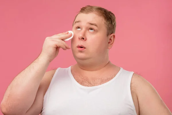 Homem gordo faz limpeza de rotina da manhã com algodão almofada rosto pele antes de barbear — Fotografia de Stock