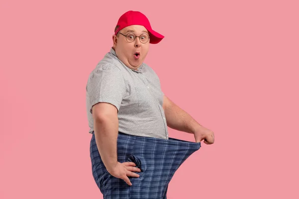 Felice sorpreso uomo obeso mostra i suoi grandi pantaloni dopo aver mantenuto la dieta per tre settimane — Foto Stock