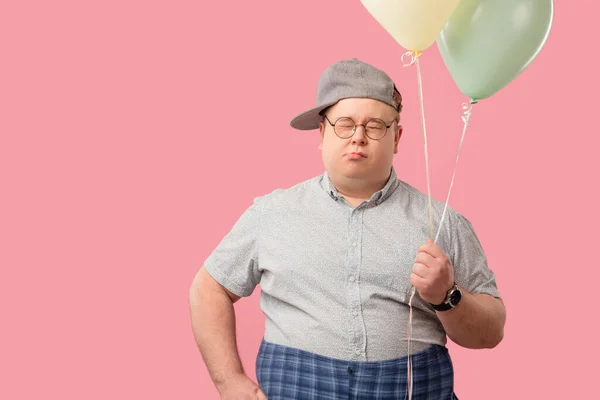 Кумедна людина, дуже схожа на Вінні Пуха з повітряними кульками ізольованими над рожевим. — стокове фото