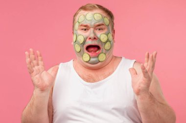 Yüzünü kilden maskeyle gören öfkeli adam çığlık atıyor.