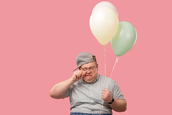 Retrato de hombre adulto llorando en ropa casual gris, sosteniendo globos de aire en rosa —  Fotos de Stock