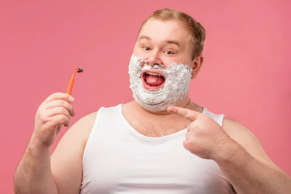 Feliz homem gordo com espuma de barbear em seu rosto e navalha isolada em rosa — Fotografia de Stock