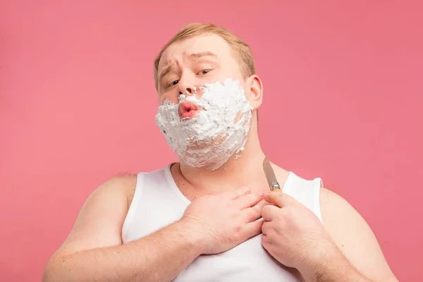 Feliz hombre regordete con espuma de afeitar en su cara y afeitadora aislado en rosa — Foto de Stock