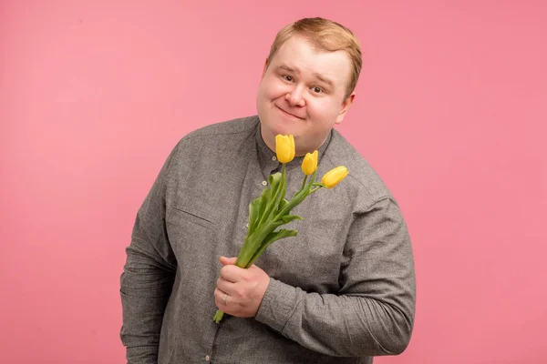 Емоційний чоловік подарував букет тюльпанів, хоче зробити сюрприз своїй дружині — стокове фото