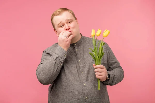 Roztomilý legrační kudrnatý chlapec s květinami přes bílé pozadí. — Stock fotografie