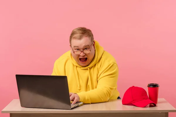 Zszokowany zaskoczony pulchny mężczyzna w żółtym wpatrując się w monitor laptopa z otwartymi ustami. — Zdjęcie stockowe