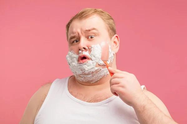 Imagen de regordete sorprendido hombre sorprendido con espuma de afeitar en la cara. Mirando la cámara. — Foto de Stock
