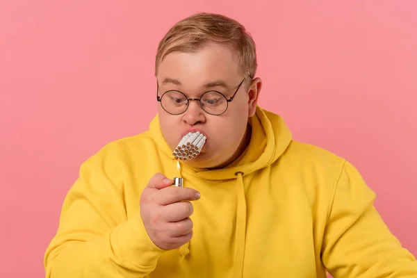 Homme obèse avec la bouche pleine de cigarettes essayant de fumer tout en même temps. — Photo