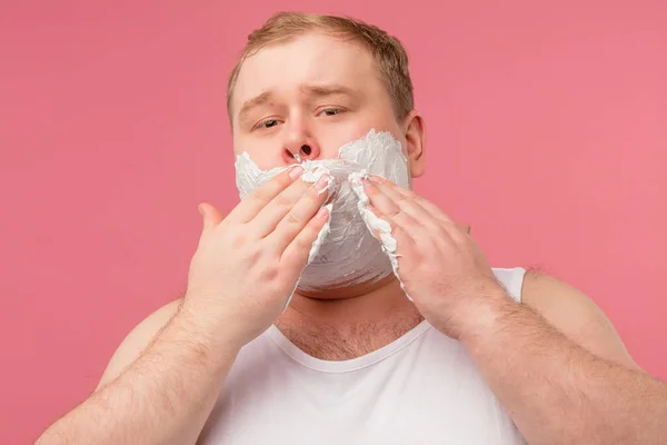 Hombre gordo trastornado en camiseta blanca con espuma en la barba, siente dolor o irritación — Foto de Stock