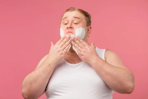Gelukkig mollige man met scheerschuim op zijn gezicht en scheermes geïsoleerd op roze — Stockfoto