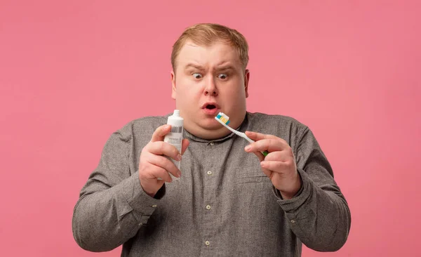 Startled persona allergica, lavarsi i denti con nuova pasta, guardando scioccato. — Foto Stock