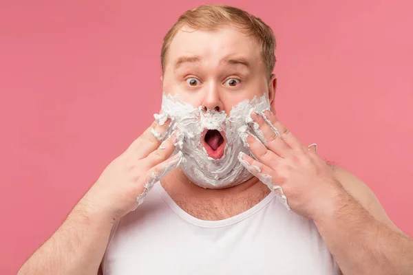 Homem espantado tem espuma de barbear no rosto, sentindo-se impressionado com novo gel de barbear — Fotografia de Stock