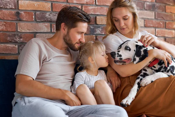 Belo casal e menina brincando com um cão — Fotografia de Stock