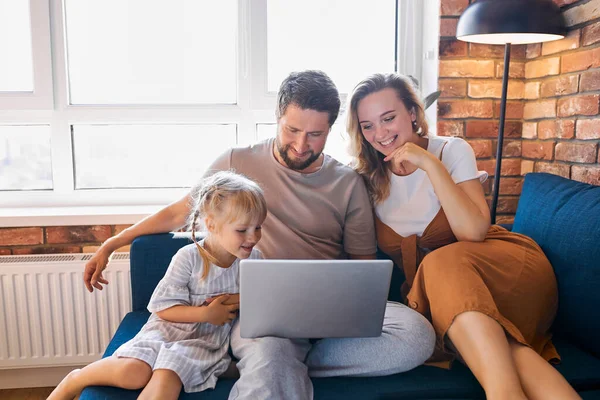 Familia caucásica sentarse usando el ordenador portátil en el sofá en casa —  Fotos de Stock