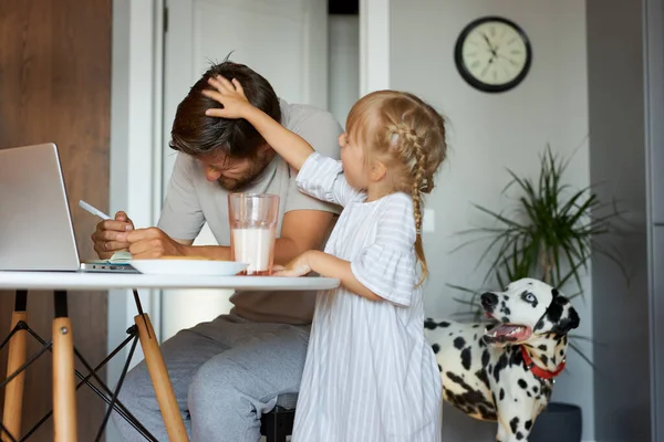 Bambina diverte padre che lavora a casa — Foto Stock