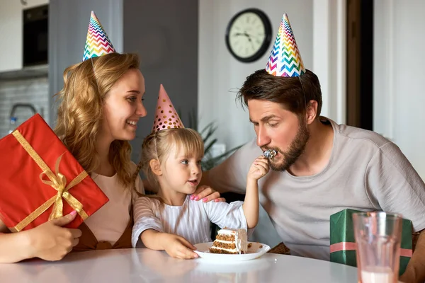 Roztomilé malé dítě dívka zachází s rodiči s narozeninovým dortem — Stock fotografie