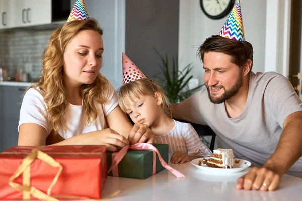 사랑 스러운 딸의 생일 선물을 꺼내 주는 행복 한 부모들 — 스톡 사진