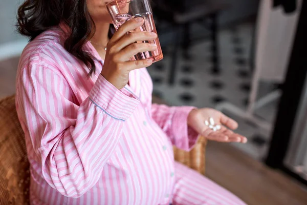 Pregnant woman drinking vitamins and minerals — Stock Photo, Image