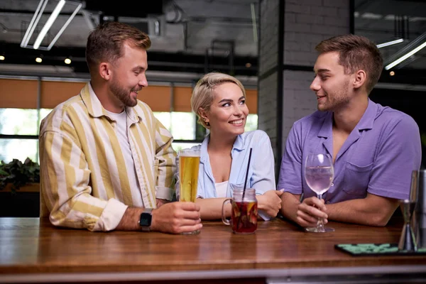 handsome guy tell jokes to friends at bar