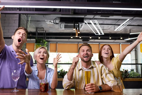 Happy friends pití piva, sledování sportovní hry nebo fotbalový zápas spolu v baru — Stock fotografie