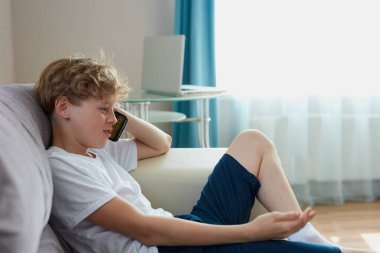 Delikanlı arkadaşınla telefonda konuşuyor.