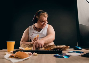 Şişman, sarışın, kulaklıklı, evde çalışan.