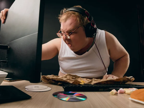 Kültürsüz bir adam yemek yiyor ve maç izliyor.