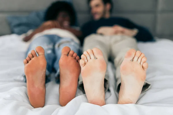 Close-up de pés de casal interracial dormindo juntos. — Fotografia de Stock