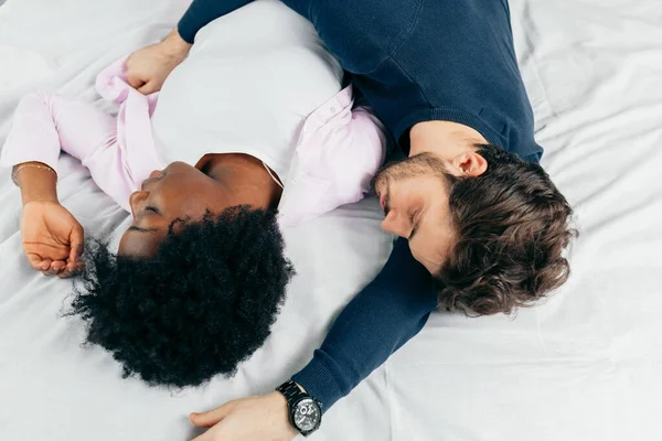 Pareja joven durmiendo juntos en la cama en el dormitorio, abrazándose dulcemente —  Fotos de Stock