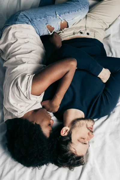 Young couple sleeping together on bed in bedroom, embracing each other sweetly — Stock Photo, Image