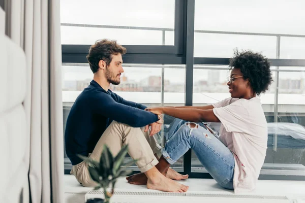 Romantisch gemengd ras paar staan bij het raam denken over hun toekomst. — Stockfoto