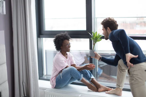 Romantisch gemengd ras paar staan bij het raam denken over hun toekomst. — Stockfoto