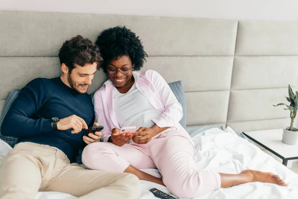 Amerikaanse man delen van foto 's met zijn mooie Afrikaanse vriendin in de slaapkamer — Stockfoto