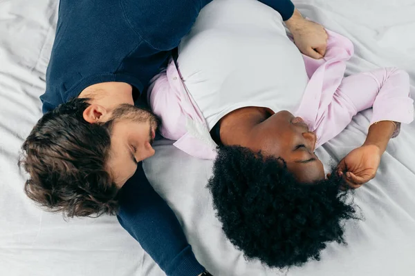 Νεαρό ζευγάρι κοιμάται μαζί στο κρεβάτι στην κρεβατοκάμαρα, αγκαλιάζονται γλυκά — Φωτογραφία Αρχείου