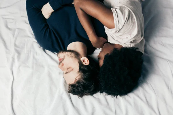 Fiatal pár alszik együtt az ágyban a hálószobában, átölelik egymást édesen — Stock Fotó