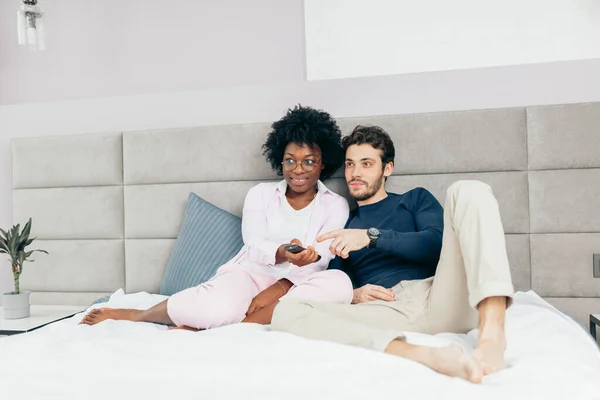 Gemengde race paar rusten op bed en samen tv kijken in de vrije dag — Stockfoto