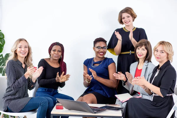 Multiétnica equipe feminina aplaudindo durante seminário de negócios na sala de conferências — Fotografia de Stock