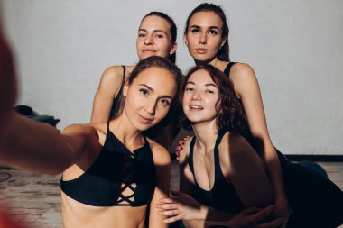 Gülümseyen güzel kadınlar spor yaparken selfie çekiyorlar.