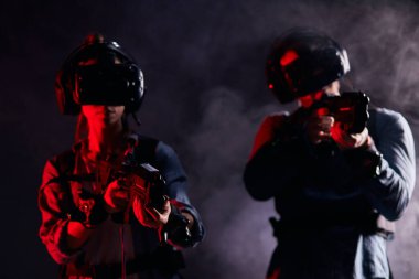 VR oyunu için özel ekipman giyen iki kişi